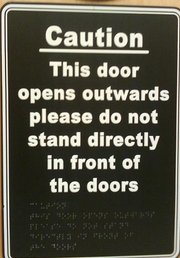 This door opens outwards please do not stand directly in front of doors. (Also in braille).